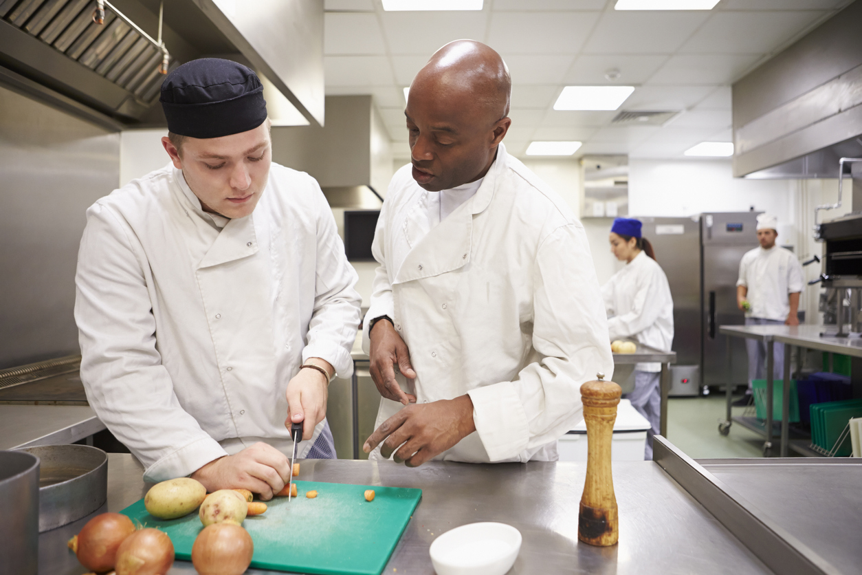 Teacher Helping Students Training To Work In Catering Teacher Helping Students Training To Work In Catering